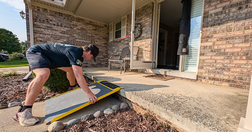 Professional mover setting up ramp at home entrance, demonstrating careful preparation and accessibility solutions for efficient residential moving services